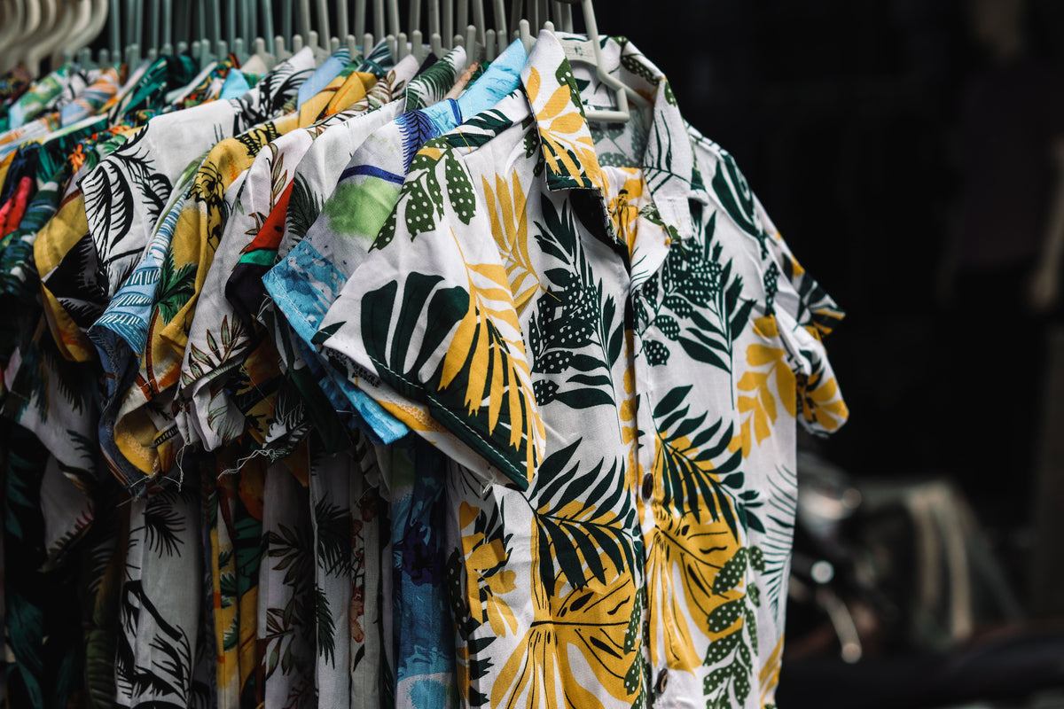 Playeras con estampado sublimado a color colgadas en tienda
